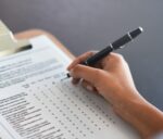 Completing the survey. Cropped shot of an unrecognizable businesswoman filling in a questionnaire.