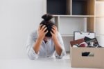 Woman employee used his hand to hold the head feeling sad at his desk when he received the contract