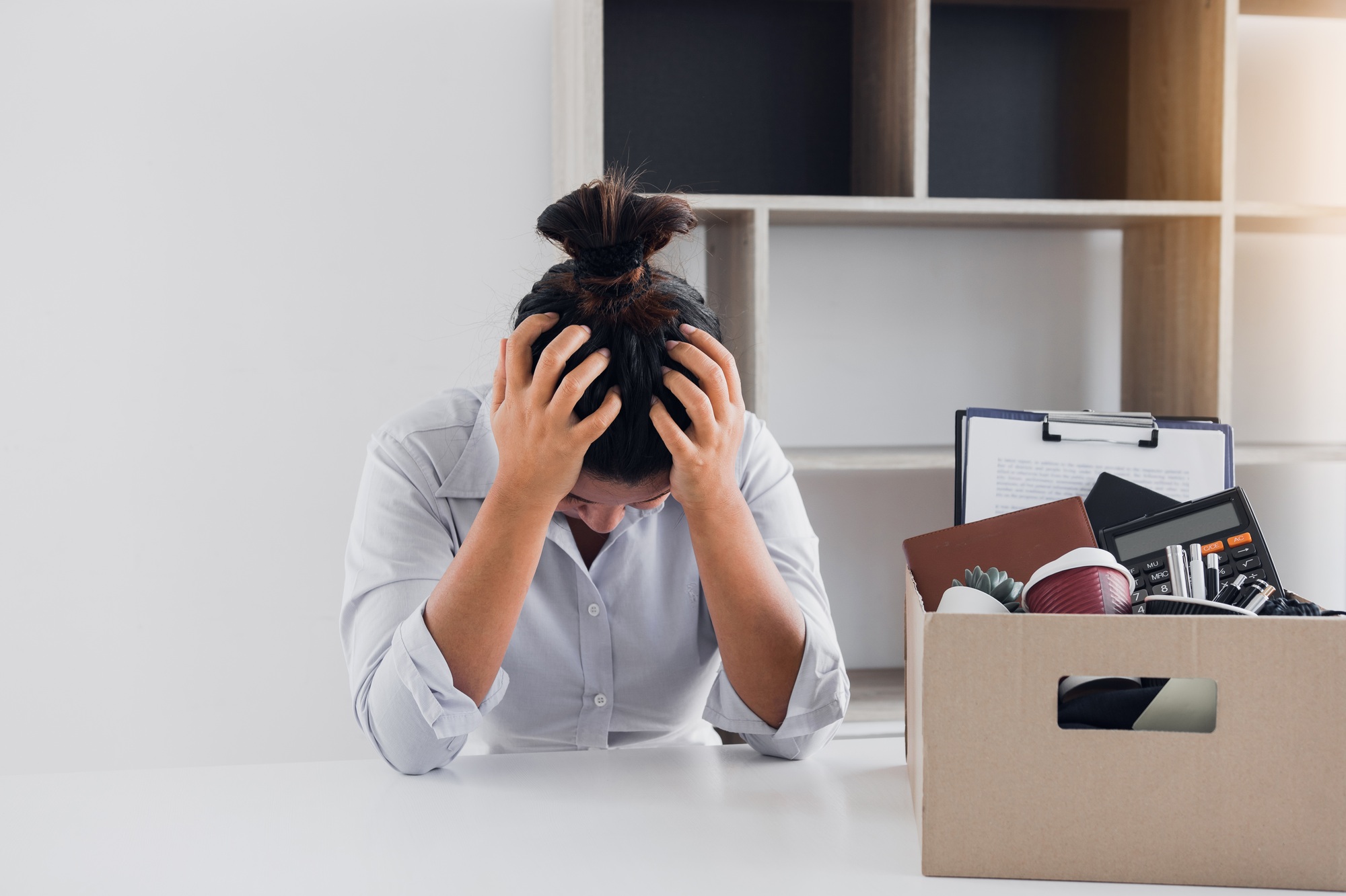 Woman employee used his hand to hold the head feeling sad at his desk when he received the contract